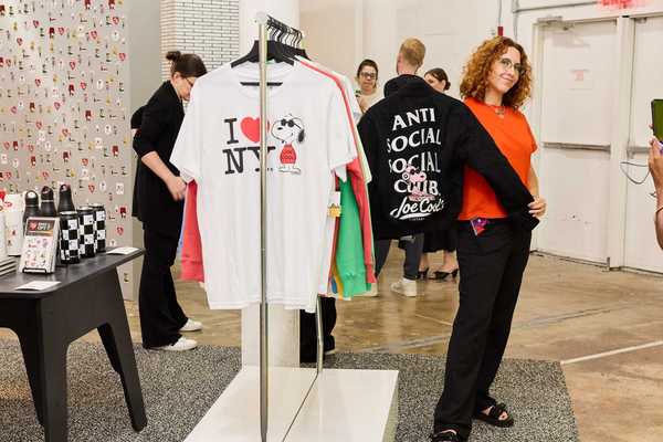 a Snoopy-themed shop with a woman holding up a Snoopy jacket and other shoppers around