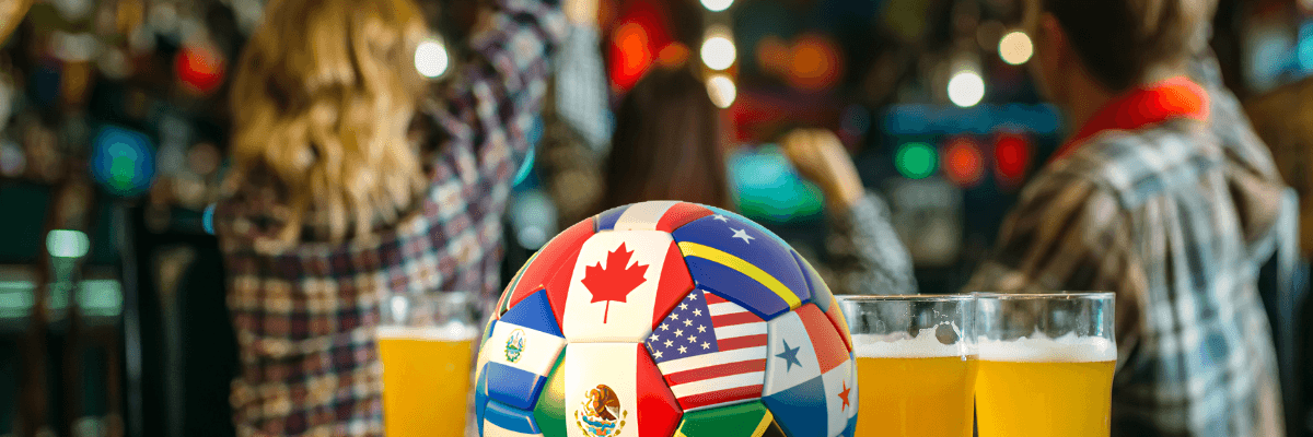 a soccer bar and pints of beer on a table with cheering fans in a bar behind