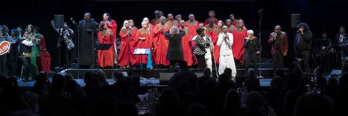 a stage with a choir in red performing