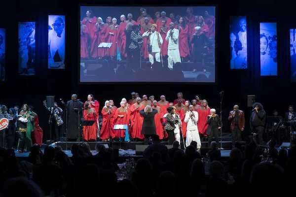 a stage with a choir in red performing