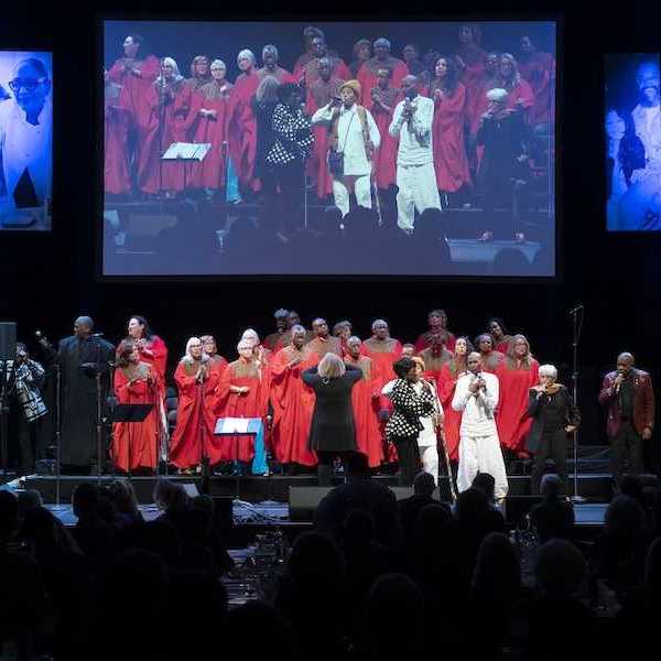 a stage with a choir in red performing