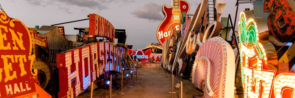a street lined with old neon signs in the setting sun
