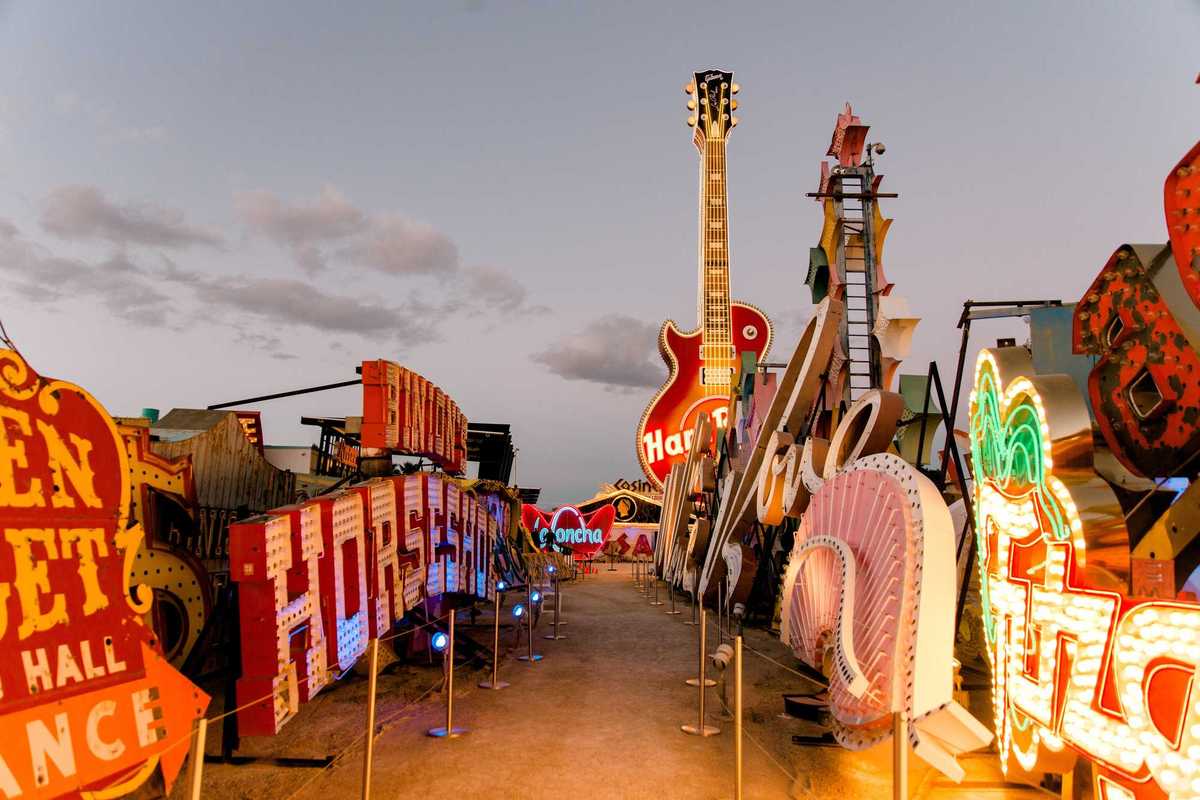 a street lined with old neon signs in the setting sun