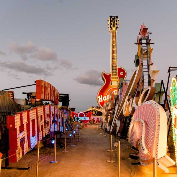 a street lined with old neon signs in the setting sun