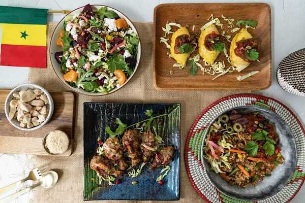 A table of dishes of food and a Senegalese flag