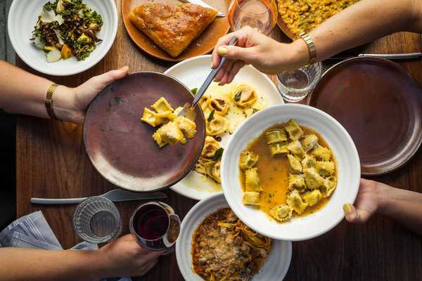 a table with someone spooning agnolotti pasta