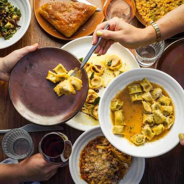 a table with someone spooning agnolotti pasta
