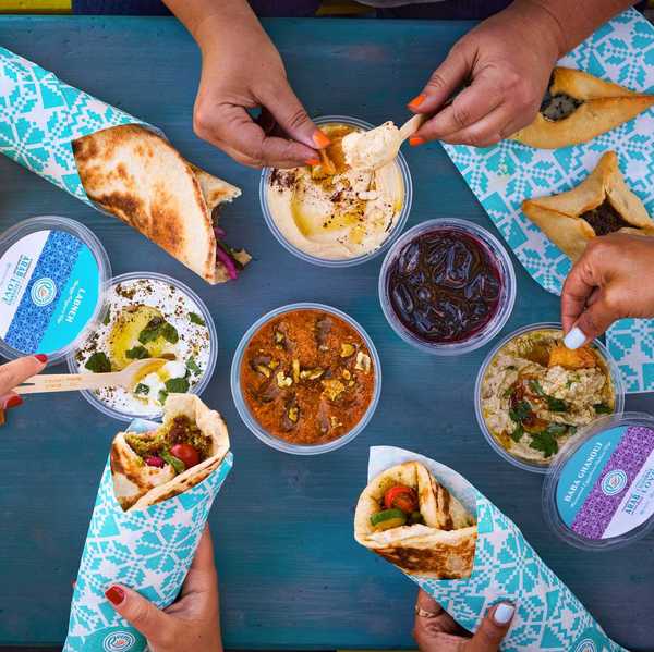 a tablescape with Middle Eastern wraps in blue paper and dips