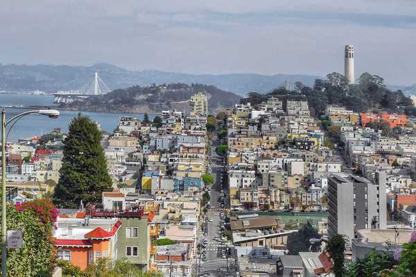 a view of san francisco with coit tower on telegraph hill on one side and the bay on the other