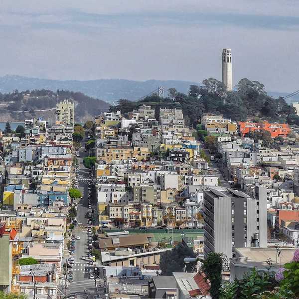 a view of san francisco with coit tower on telegraph hill on one side and the bay on the other
