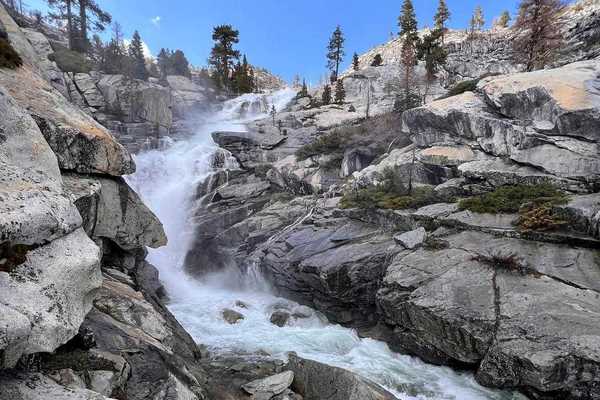 a waterfall running through granite rocks
