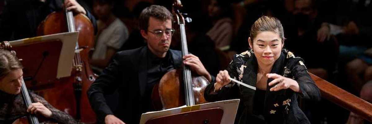 A woman conductor with an orchestra