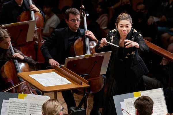 A woman conductor with an orchestra