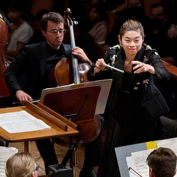 A woman conductor with an orchestra