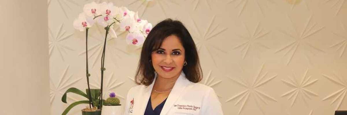 a woman doctor in a white lab coat standing in front of an orchid