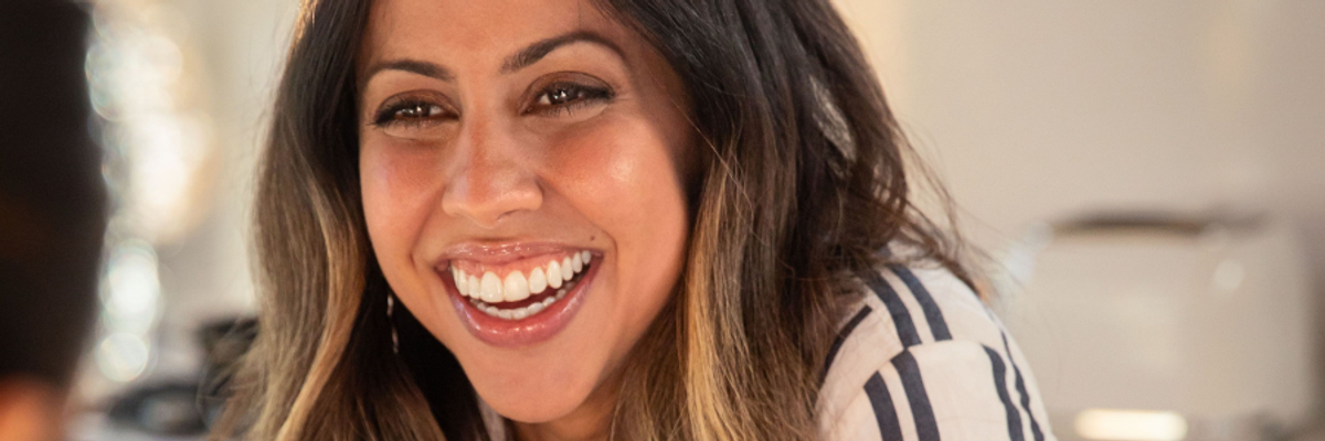 A woman smiling with an invisible teeth aligner on her teeth