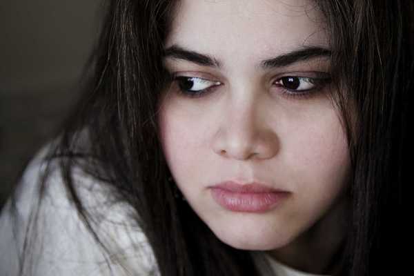 a woman with dark hair, dark eyes, and dark eyebrows