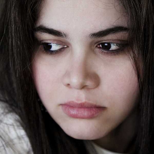 a woman with dark hair, dark eyes, and dark eyebrows