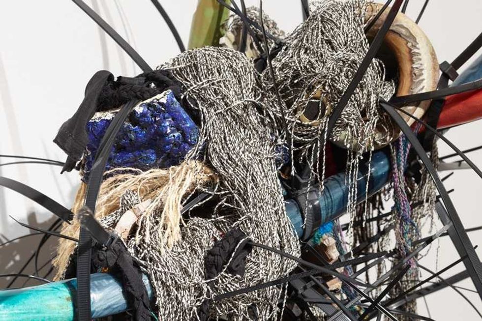 Abstract sculpture with tangled wires, ropes, and textured materials.