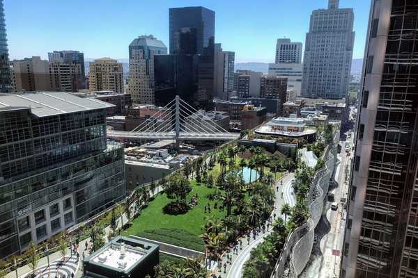 an elevated park with trees in the middle of a dense city downtown