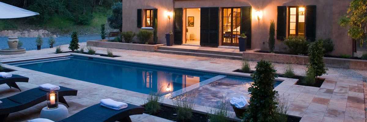 an Italianate villa with a pool deck at twilight