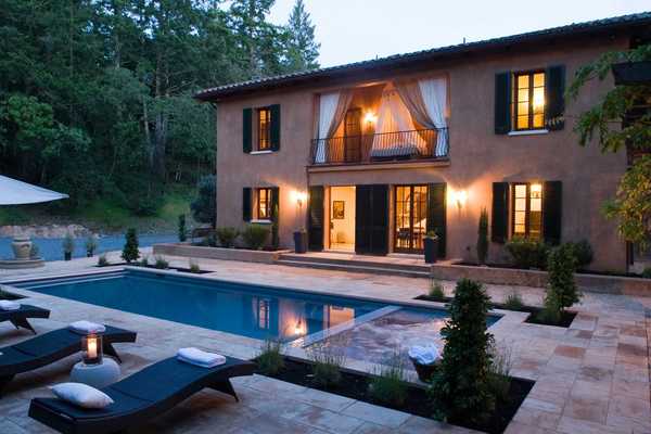 an Italianate villa with a pool deck at twilight