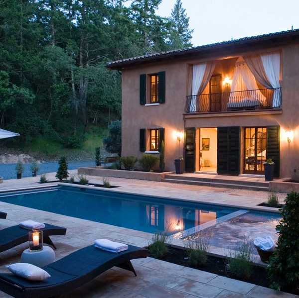 an Italianate villa with a pool deck at twilight