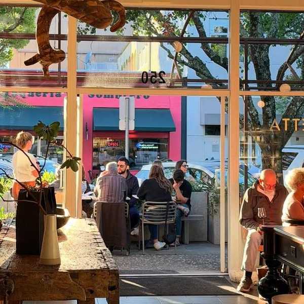 an open doorway with people sitting inside and outside on a patio