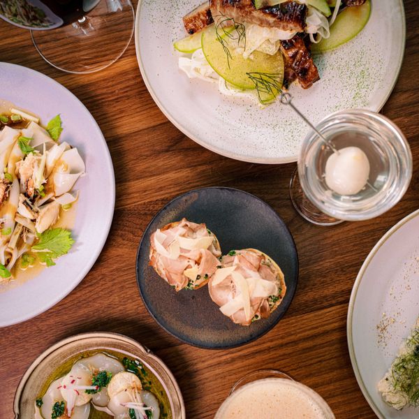 Assorted gourmet dishes with shrimp, noodles, and cocktails on a wooden table.