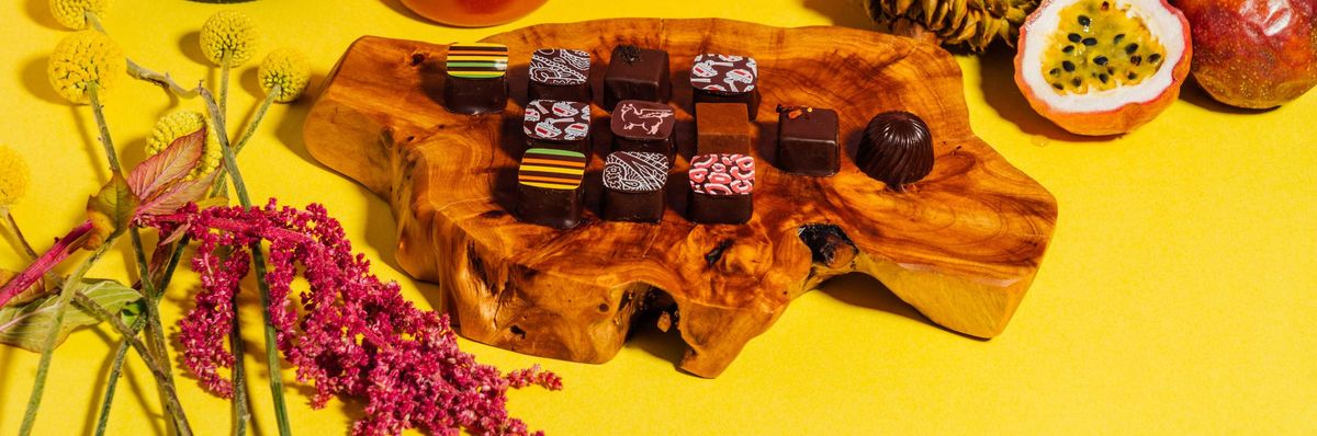 Assorted gourmet items: cognac, hot sauce, coffee, durian, passion fruit, chocolates, flowers.