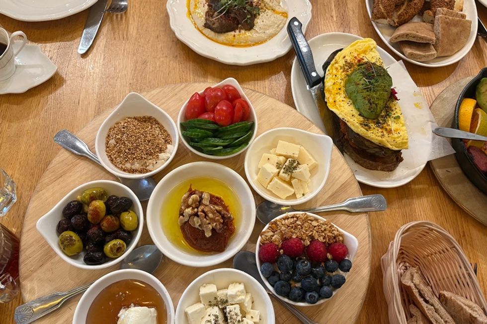 Assorted Mediterranean breakfast spread with cheese, olives, bread, and omelette.