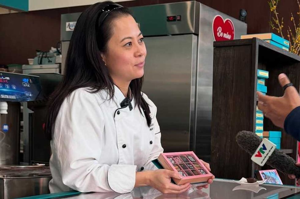Chef presenting chocolates during an interview at a counter.