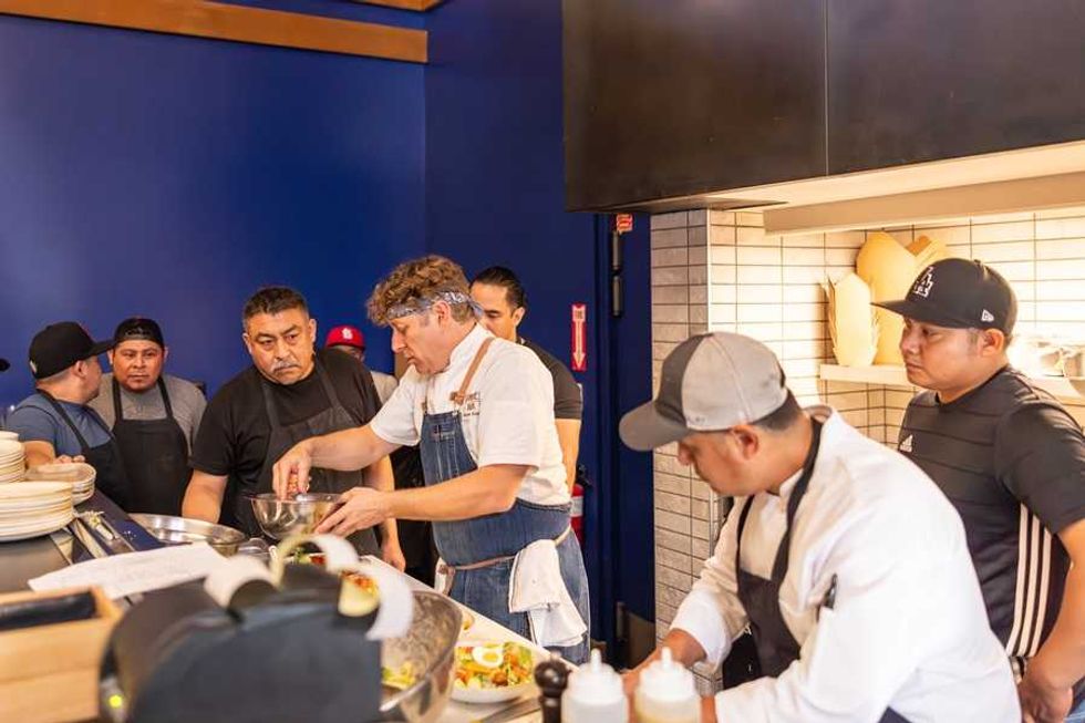 Chefs working together in a busy restaurant kitchen.