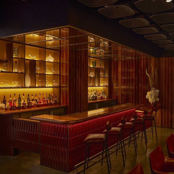 Cozy dimly-lit bar with warm wood accents and elegant glass shelving.