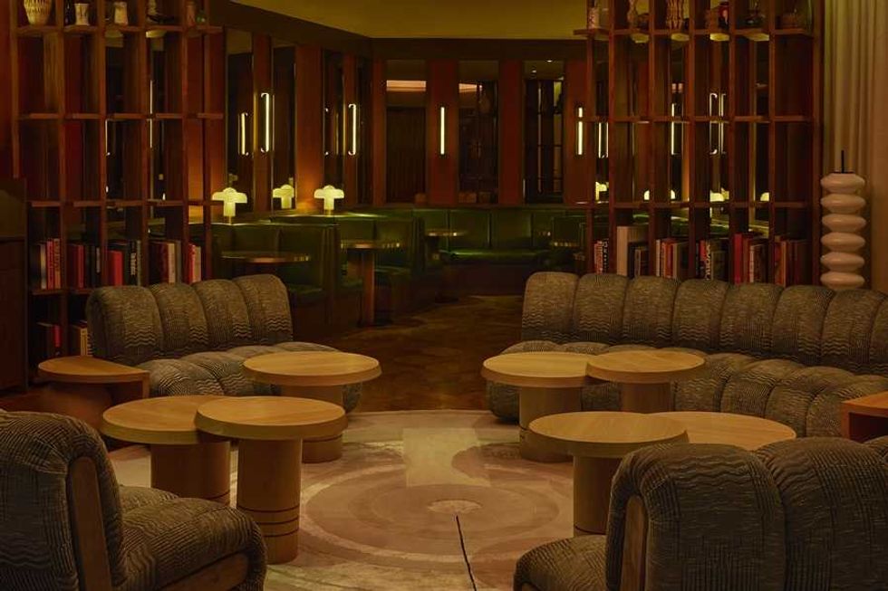 Cozy lounge with curved seating, round tables, and ambient lighting.