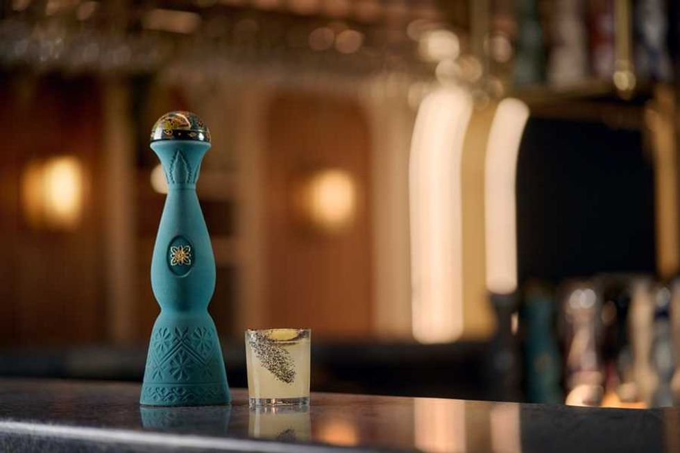 Elegant blue bottle and cocktail glass on a bar counter.
