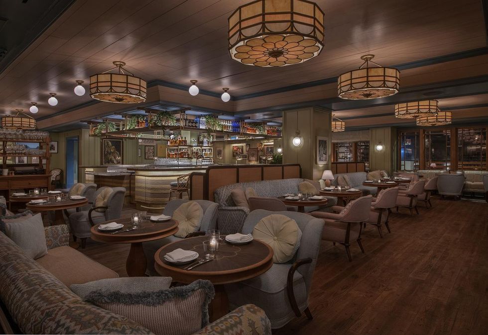 Elegant restaurant interior with cozy seating, dim lighting, and a central bar area.