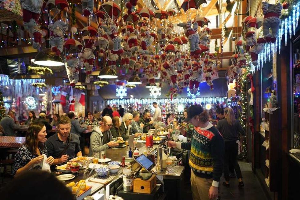 Festive bar with hanging Santa decorations and patrons enjoying a meal.