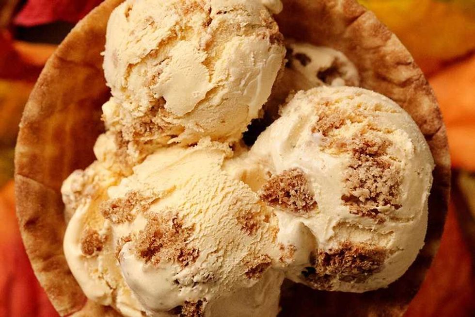 Ice cream scoops with cookie chunks in a waffle bowl.