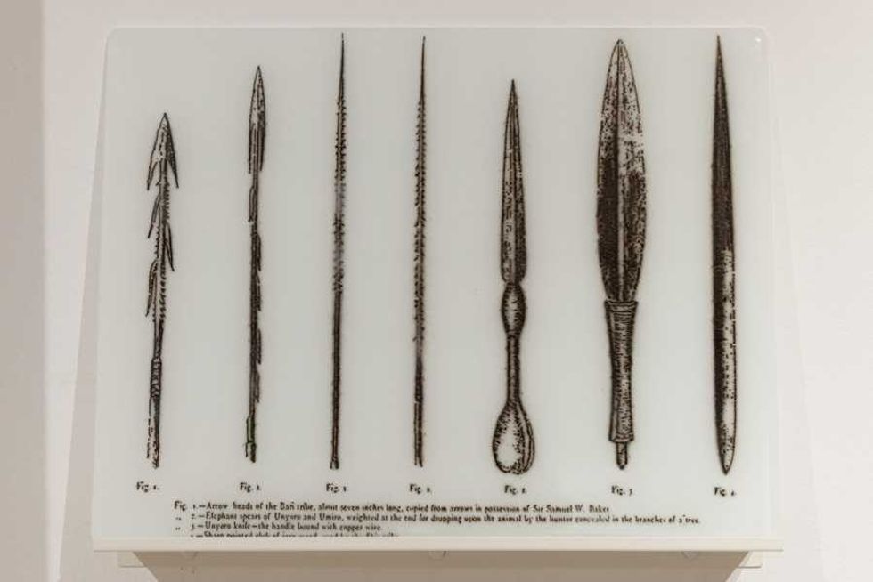 Illustration of seven spear and knife designs on a display board.