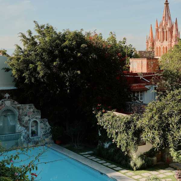 Mexican colonial pool with a gothic pink church in the background