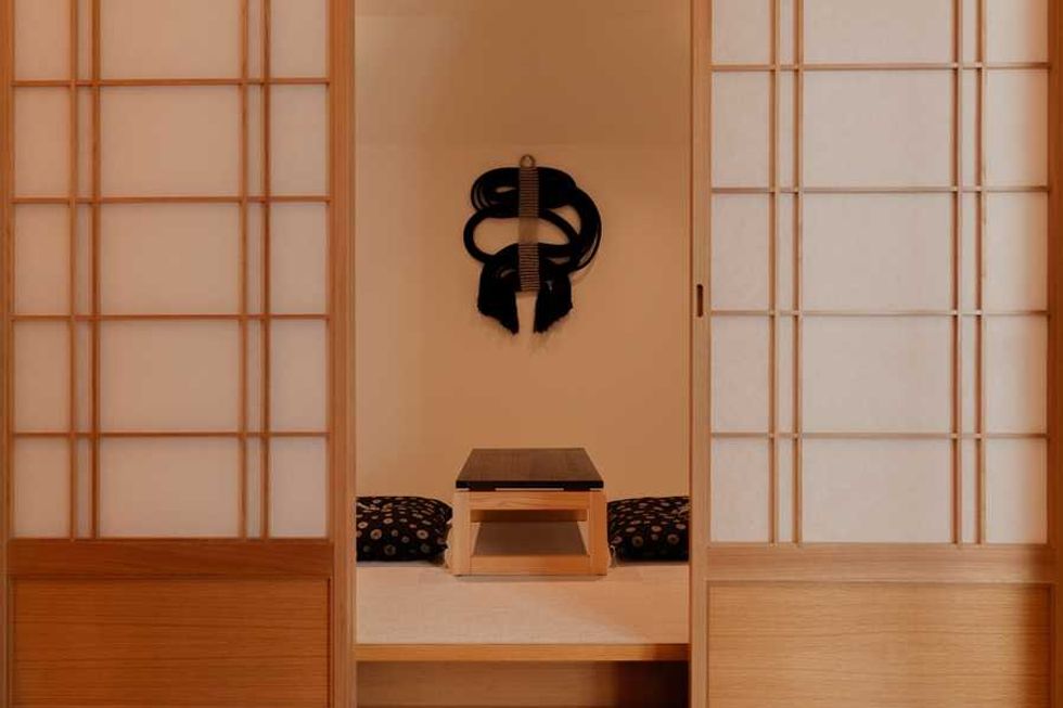 Minimalist Japanese room with wooden doors and a low table.