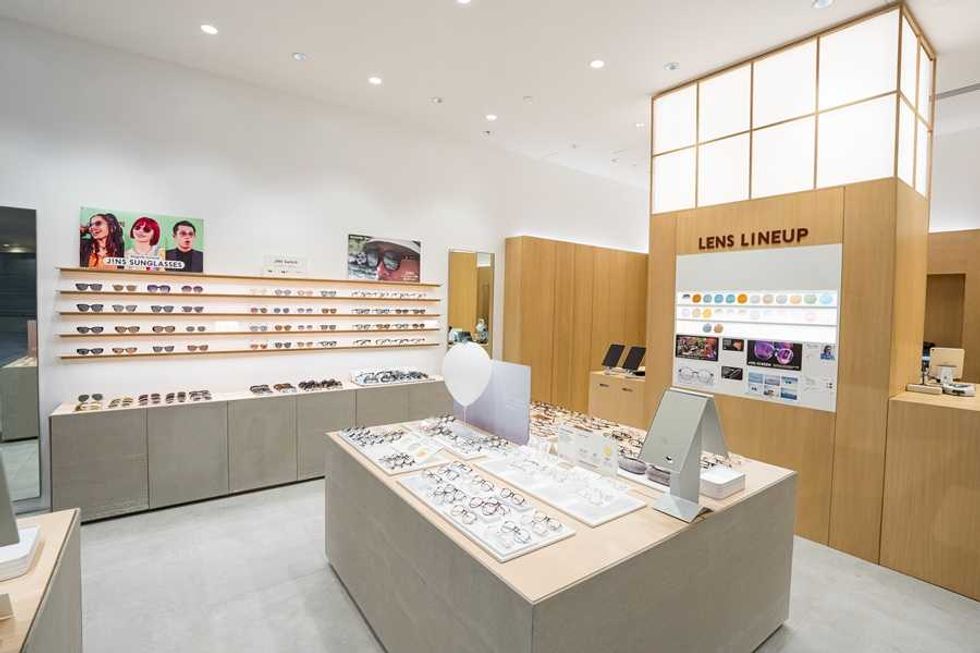 Modern optical store interior with sunglasses display and a "Lens Lineup" section.