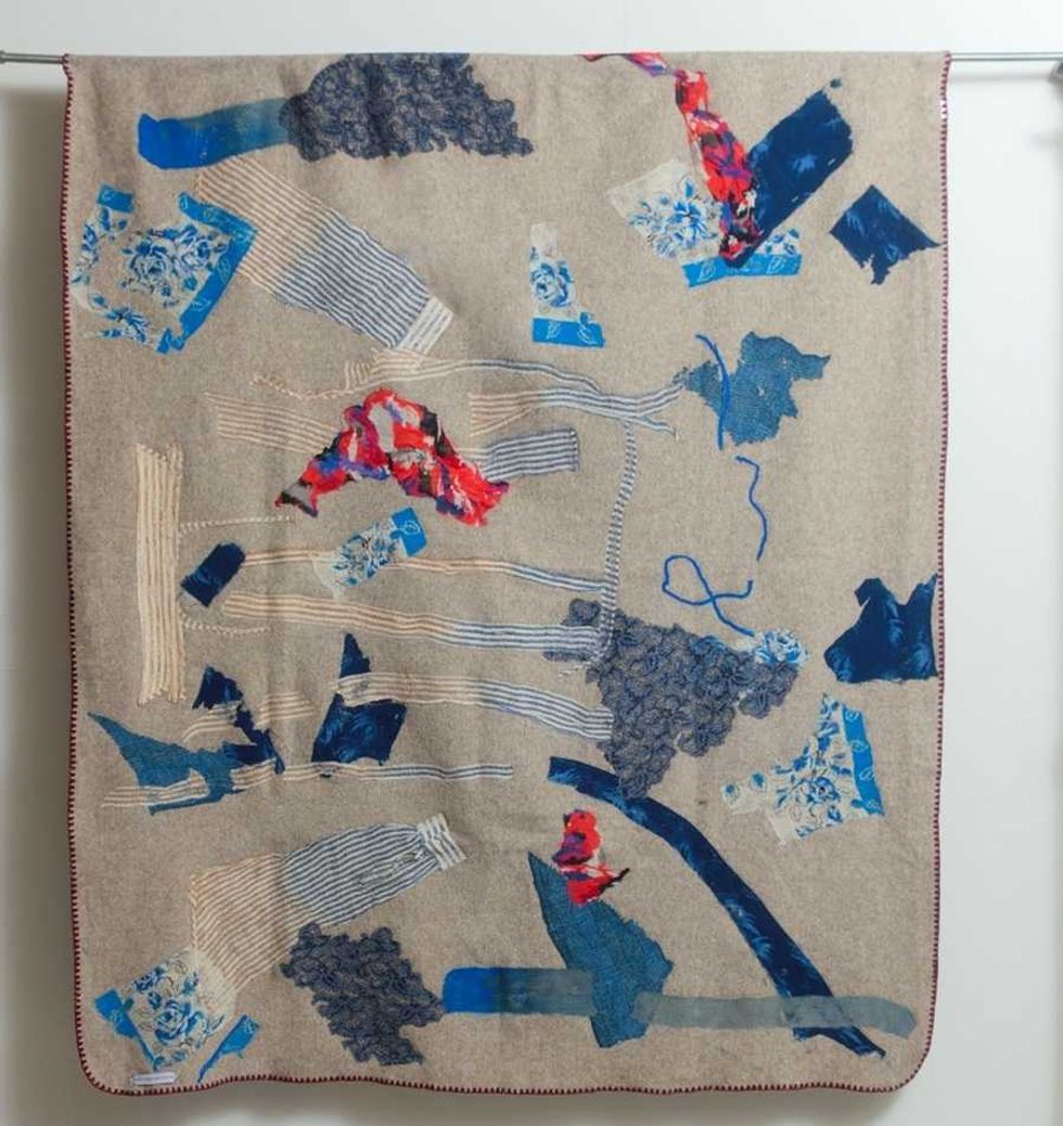 Patchwork quilt with blue, red, and beige abstract patterns.