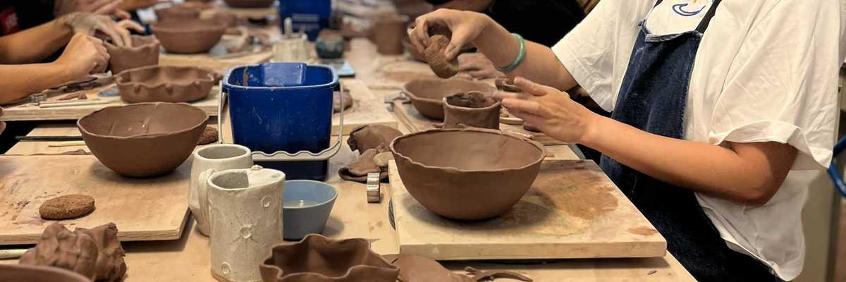 people in a class making dishes out of clay