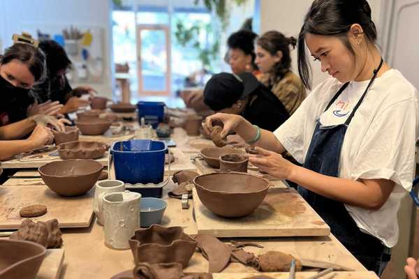 people in a class making dishes out of clay