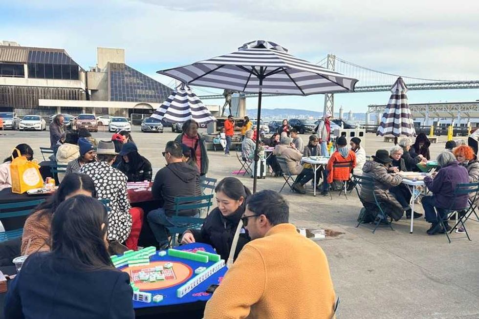 people playing mahjong at outdoor tables in san francisco