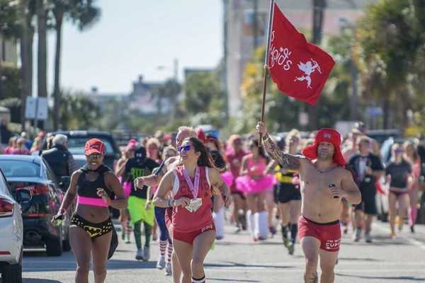 people running in their underwear, one with a cupid flag