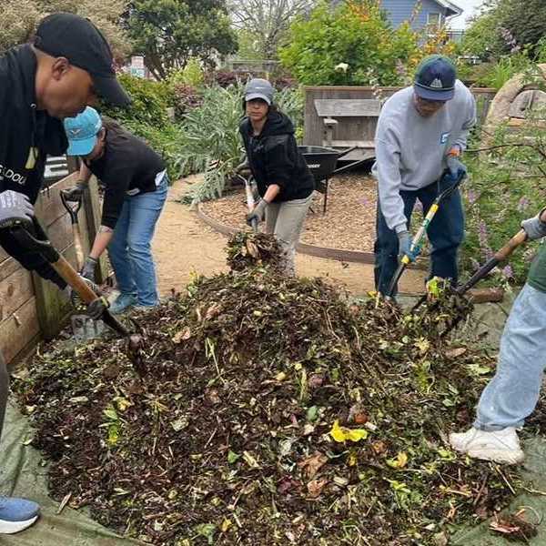 people shoveling compost