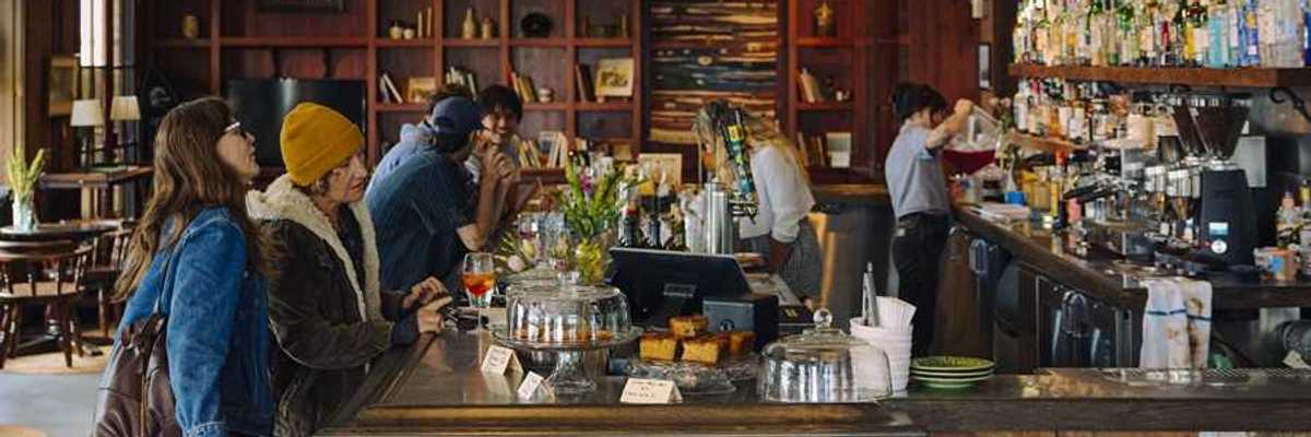 people sitting at a cozy, rustic bar with stylish shelves in the background